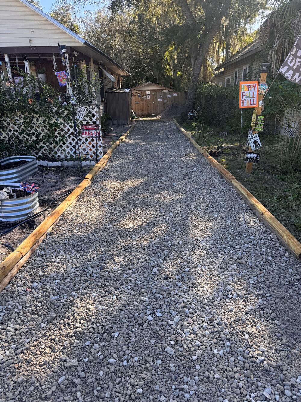 Long #57 rock path with timber borders leading to a backyard shed