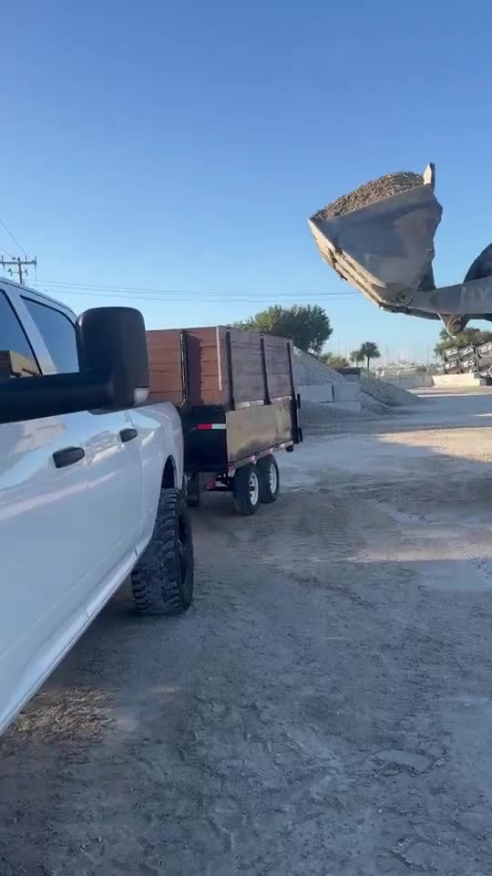Loader filling the dump trailer with rock